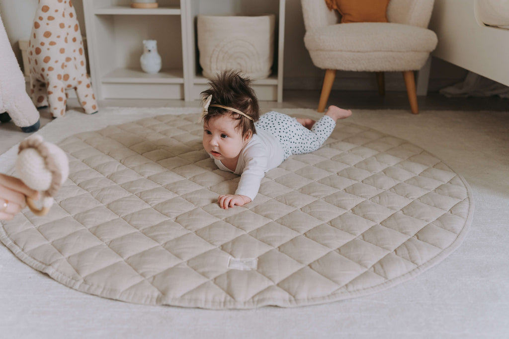 Baby crawling on our Ivory Quilted Linen Baby Play Mat UK towards their mom in the nursery